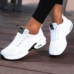 White athletic shoes with black accents on a wooden floor
