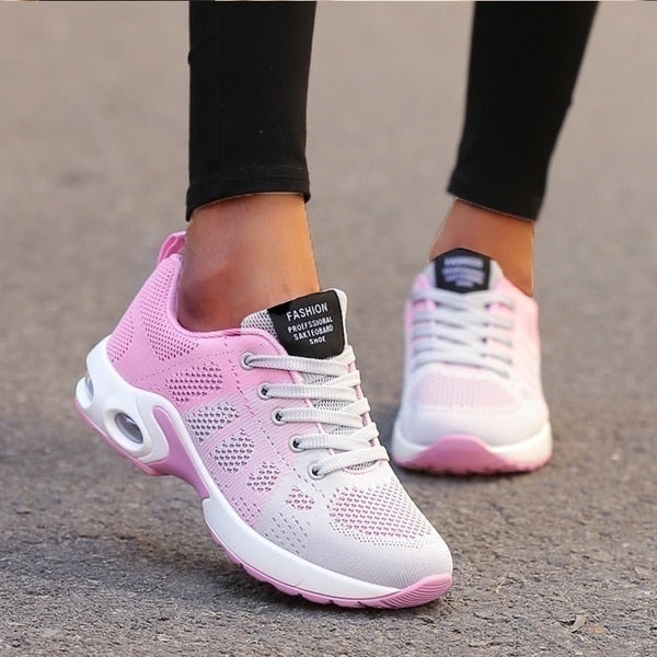 Pink and white sneakers worn on a blurred background