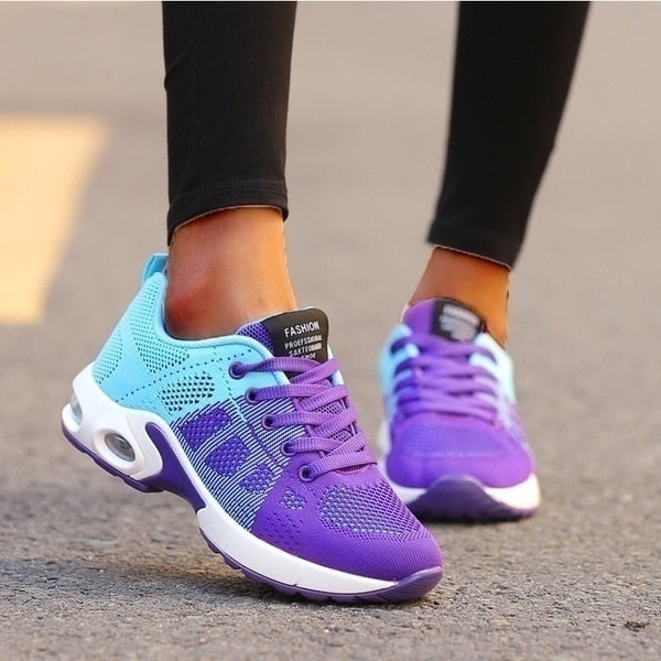 Purple and blue running shoes worn on a blurred street background