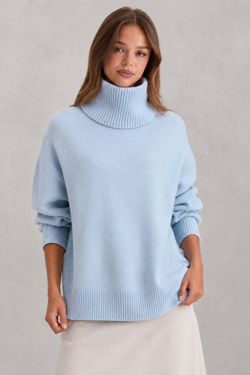 Woman wearing a light blue turtleneck sweater against a plain background