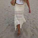 Person wearing a white lace skirt on a sandy beach