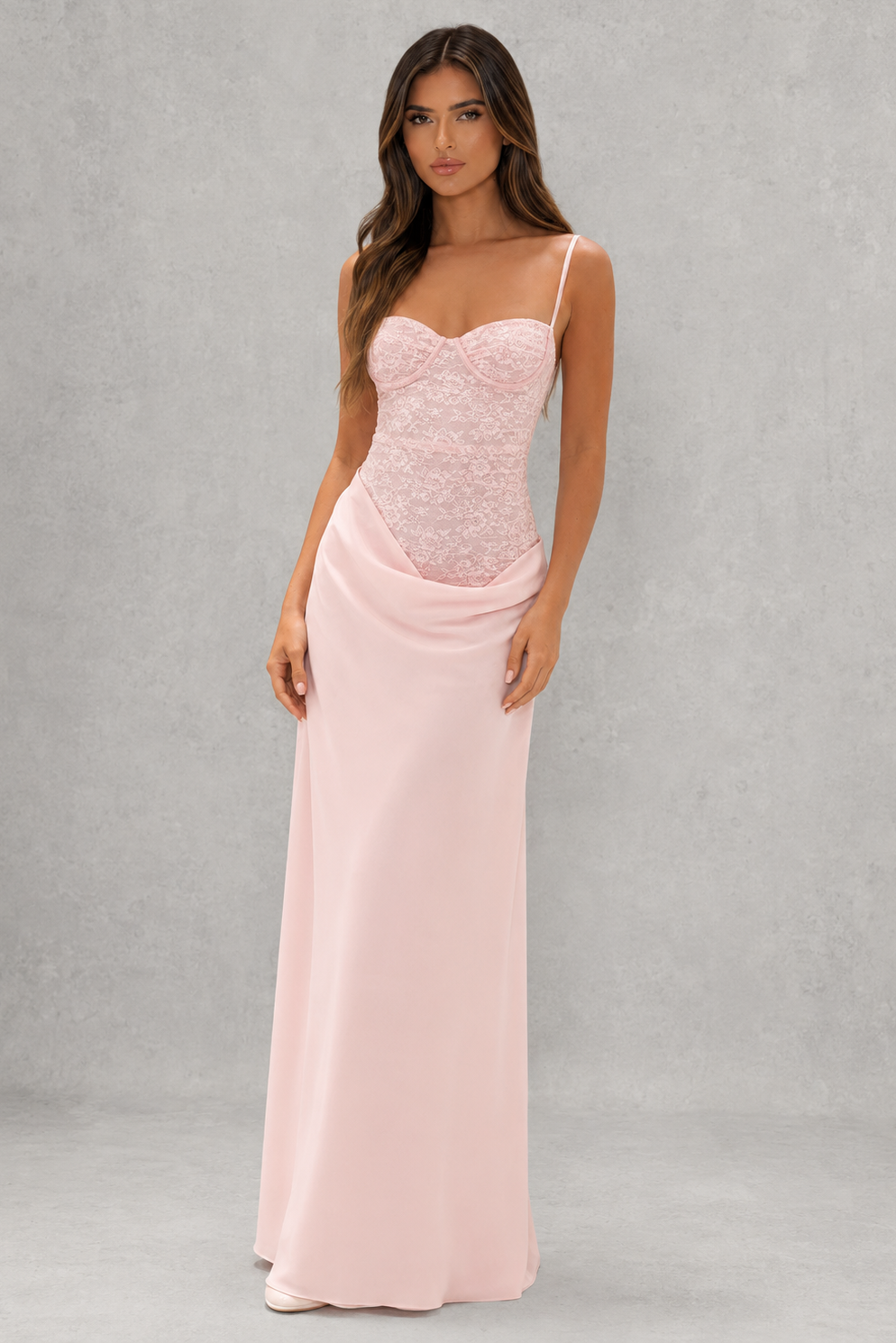Woman wearing a pink evening gown against a gray background