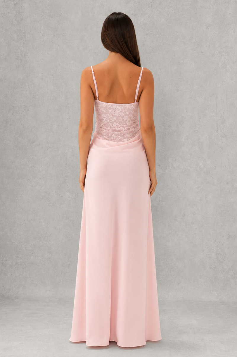 Woman wearing a pink evening gown with lace bodice on a gray background
