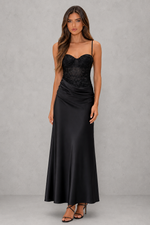 Woman wearing a black evening gown against a gray background