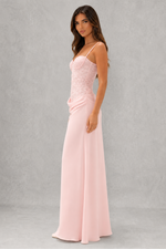 Woman wearing a pink evening gown against a gray background