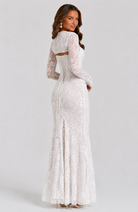 Woman wearing a white lace dress on a gray background