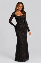 Woman wearing a black lace dress on a gray background