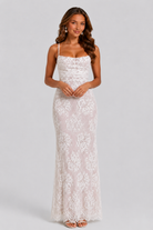 Woman wearing a white lace dress on a gray background