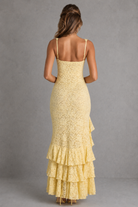 Woman wearing a yellow lace dress with a gray background