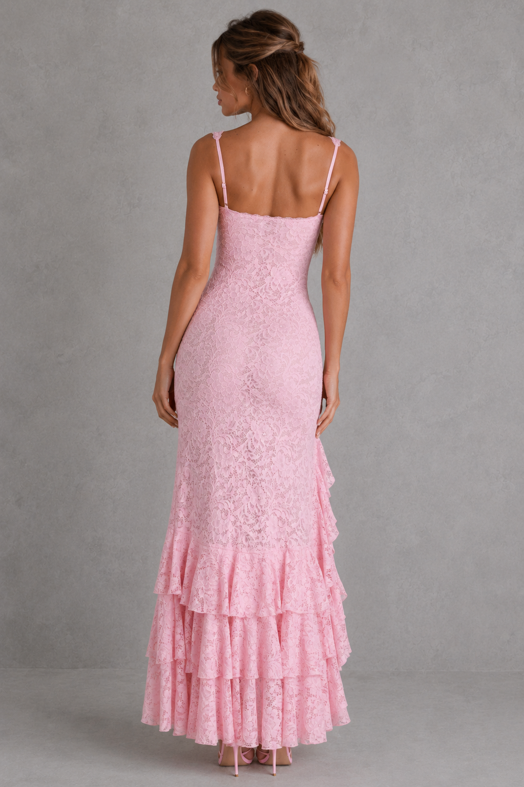 Pink lace dress with thin straps on a gray background