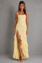 Woman wearing a yellow lace dress with a gray background