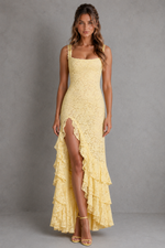 Woman wearing a yellow lace dress with a gray background