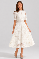 Woman wearing a white lace dress on a gray background