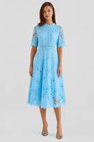 Woman wearing a light blue lace dress on a white background