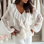 Woman wearing a white ruffled blouse in a clothing store setting