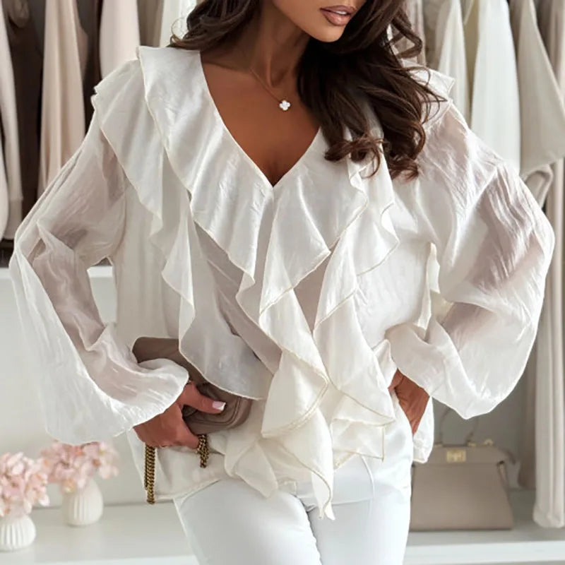 Woman wearing a white ruffled blouse in a clothing store setting
