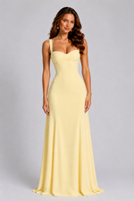 Woman wearing a yellow evening gown against a gray background
