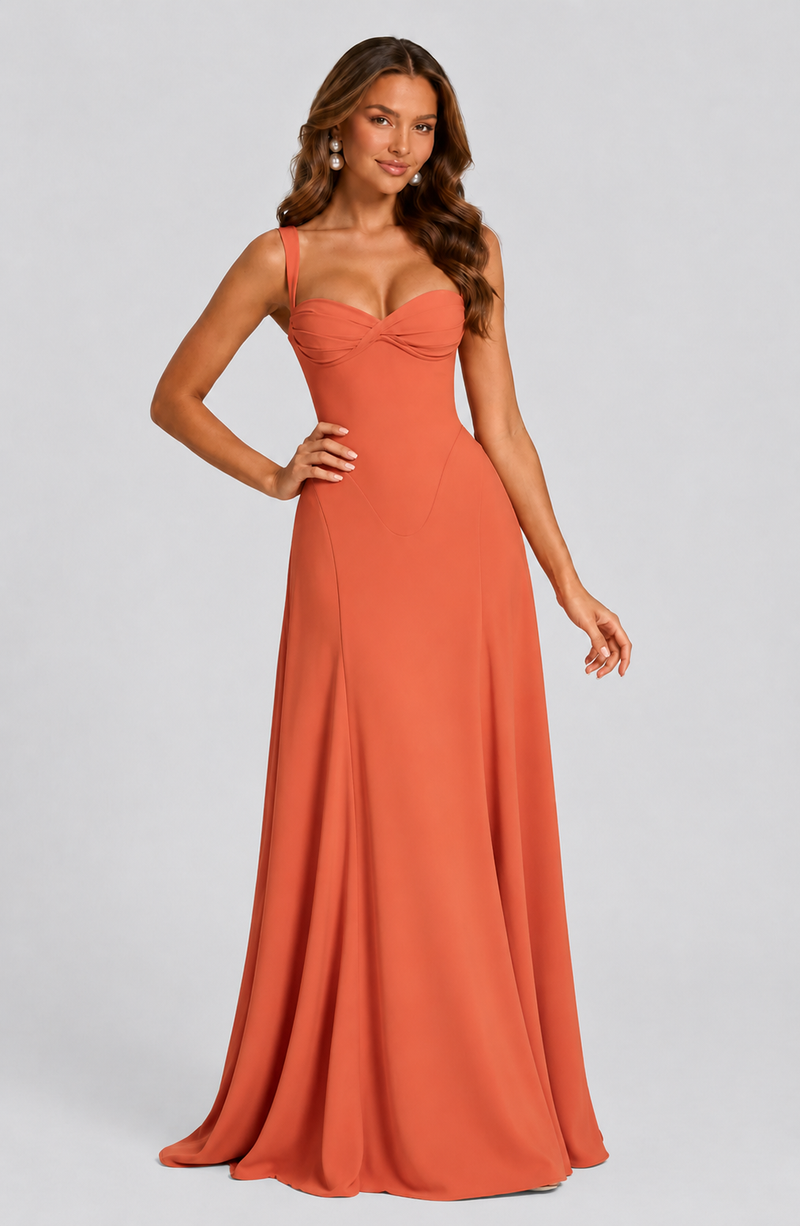 Woman wearing a long orange dress on a gray background