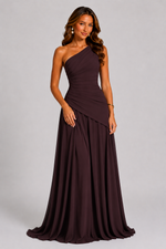 Woman wearing a one-shoulder brown evening gown on a gray background