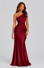 Woman wearing a burgundy one-shoulder gown on a gray background