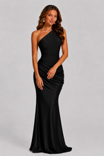 Woman wearing a black one-shoulder gown on a gray background
