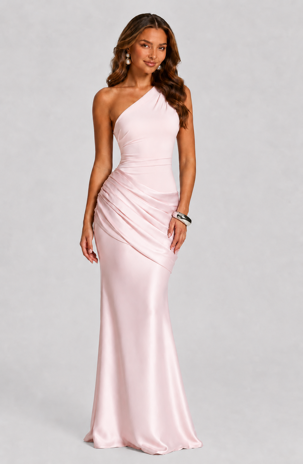 Woman wearing a pink one-shoulder gown on a gray background