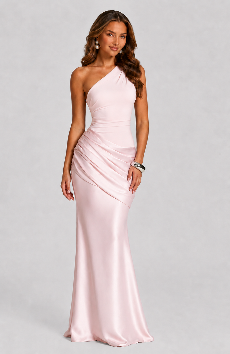 Woman wearing a pink one-shoulder gown on a gray background