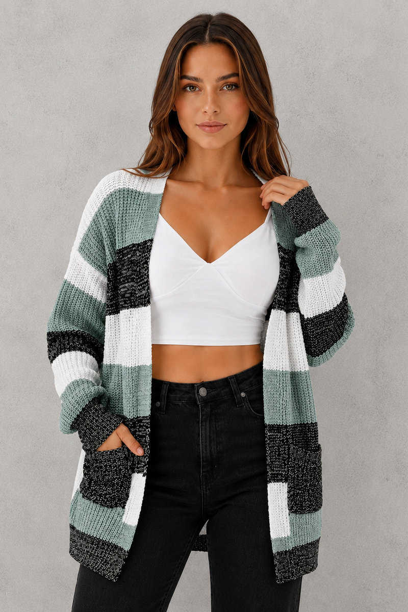 Woman wearing a striped cardigan over a white top and black pants on a gray background