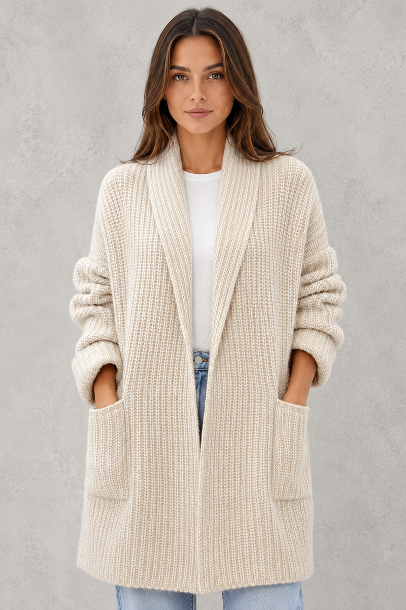 Woman wearing a beige cardigan against a gray background