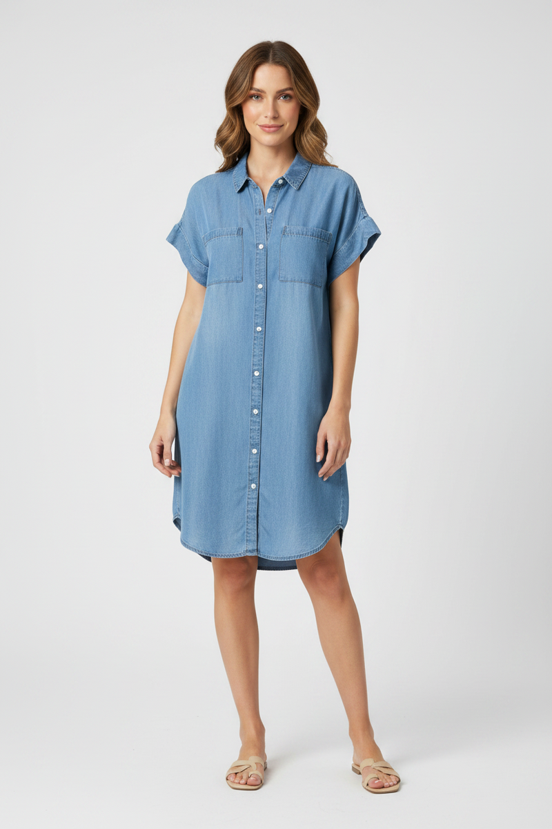 Woman wearing a blue denim dress against a neutral background