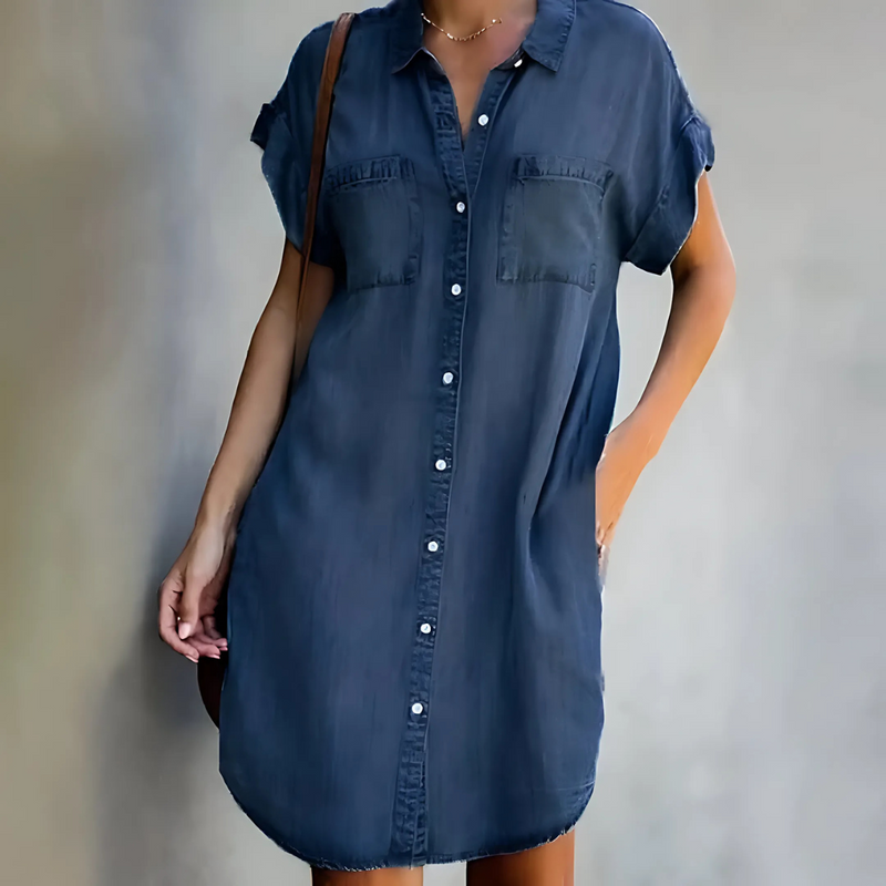 Woman wearing a blue denim dress against a neutral background
