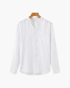 White shirt on a wooden hanger against a white background