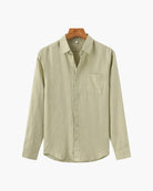 Beige button-up shirt on a hanger against a white background