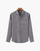 Gray button-up shirt on a hanger against a white background