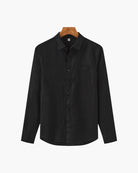 Black shirt on a hanger against a white background
