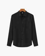 Black shirt on a hanger against a white background