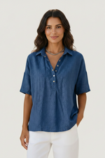 Woman wearing a blue button-up shirt with a plain background
