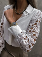 White blouse with lace sleeves and a watch on a neutral background