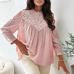 Woman wearing a pink blouse with lace details in a home setting