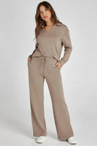 Woman wearing a beige lounge set on a white background