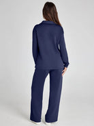 Person wearing a navy blue outfit on a light gray background