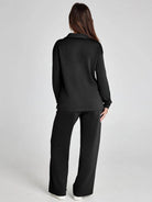 Person wearing a black outfit on a plain background