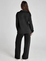 Person wearing a black outfit on a plain background