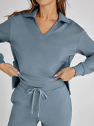 Person wearing a gray tracksuit on a plain background