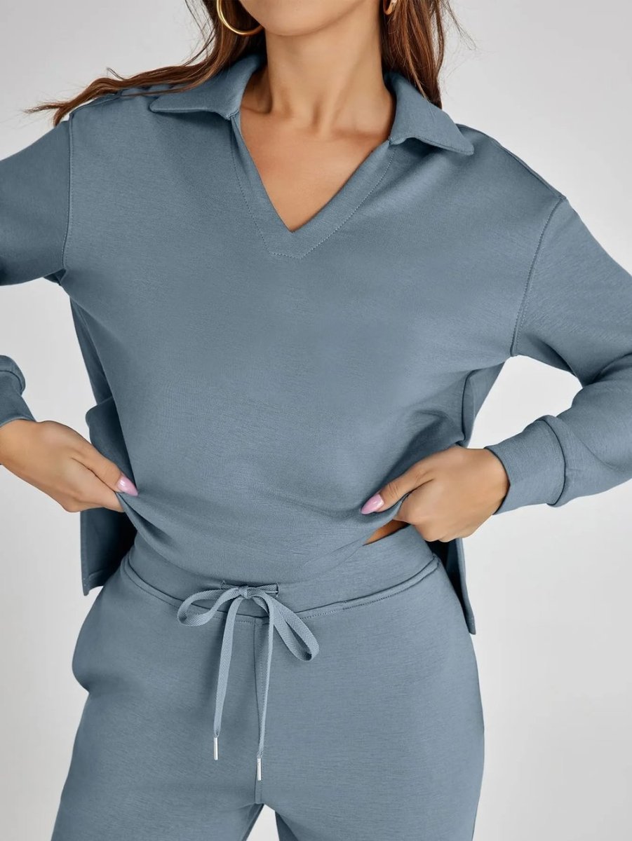 Person wearing a gray tracksuit on a plain background