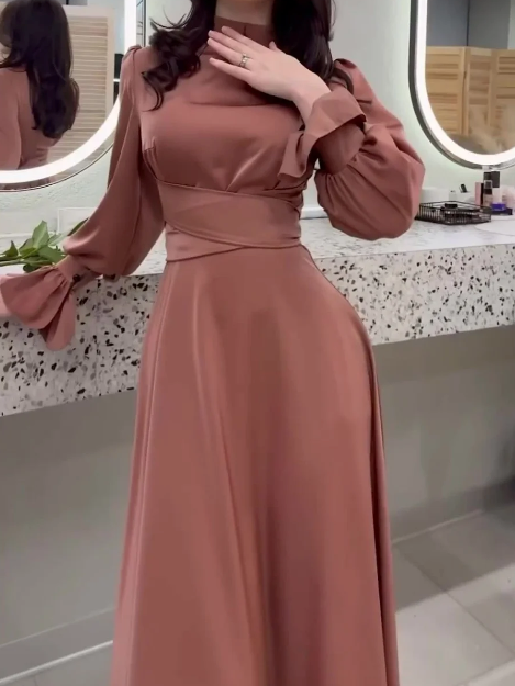 Woman wearing a long brown dress in a bathroom setting