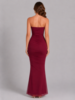 Burgundy strapless gown on a gray background