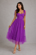 Woman wearing a purple dress against a gray background