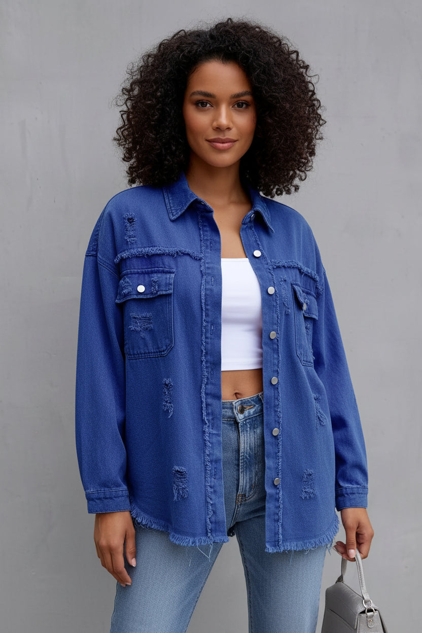 Woman wearing a blue denim jacket and jeans against a gray background