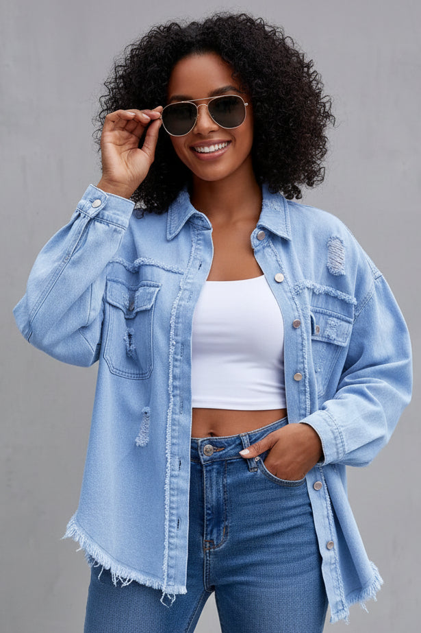 Woman wearing a light blue denim jacket and jeans against a gray background